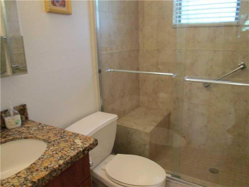 1925 Madison Street, Unit 4 Hollywood, FL 33020 - Photo 9 of 11 a white toilet sitting next to a bathroom sink