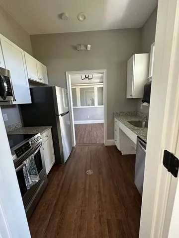 a kitchen with a sink and wooden floor