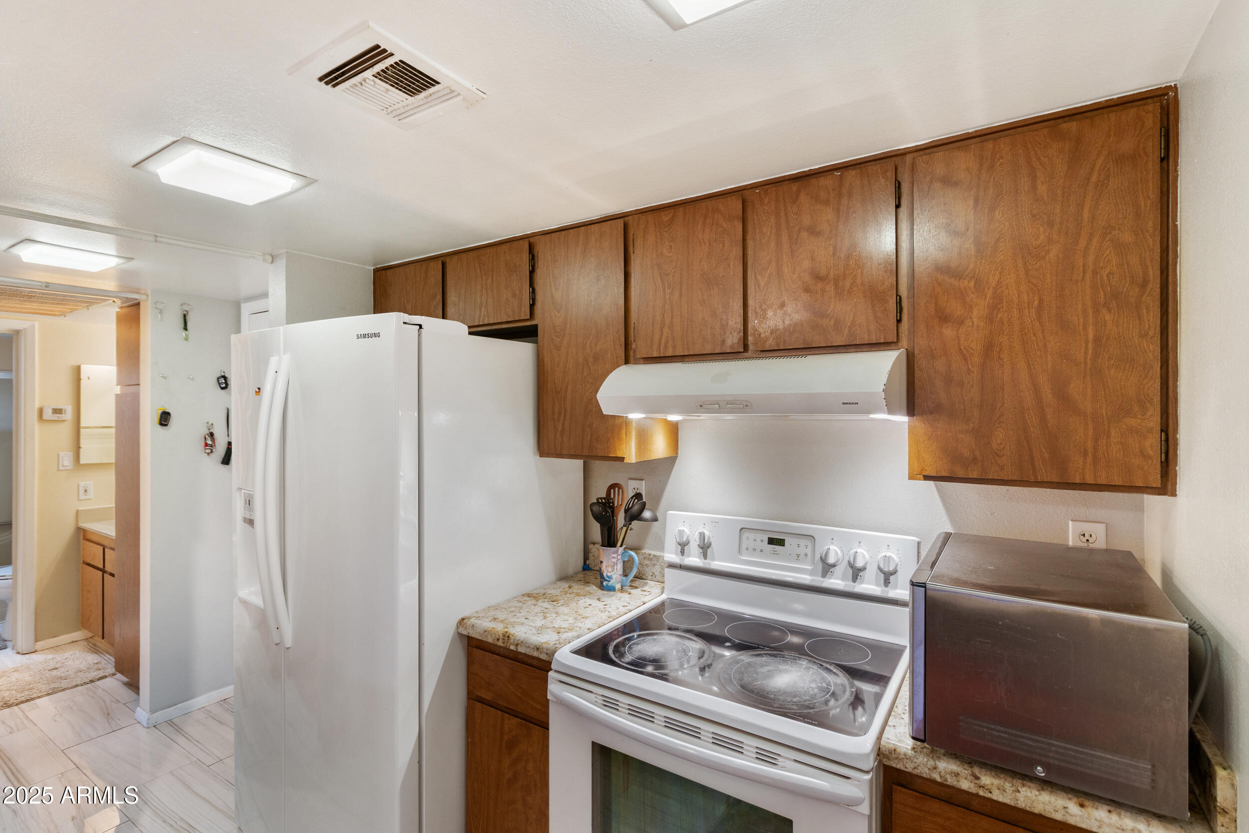 3033 East Devonshire Avenue, Unit 3003 Phoenix, AZ 85016 - Photo 11 of 45 a kitchen with a stove and a refrigerator