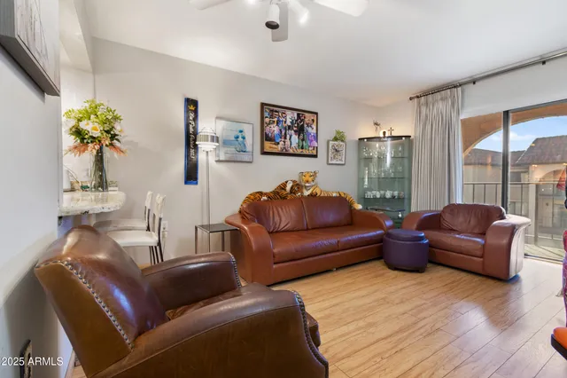 a living room with furniture ceiling fan and a wooden floor