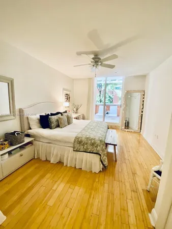 a spacious bedroom with a bed and wooden floor