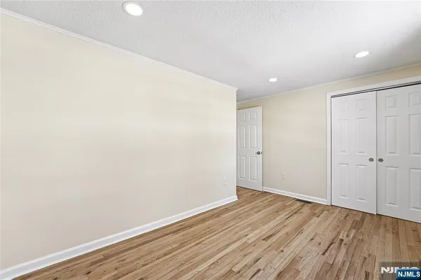 a view of an empty room with wooden floor