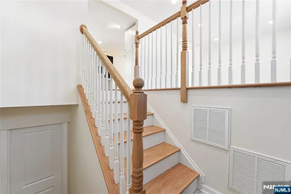 a view of staircase with railing and white walls
