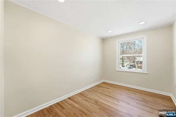 an empty room with wooden floor and window