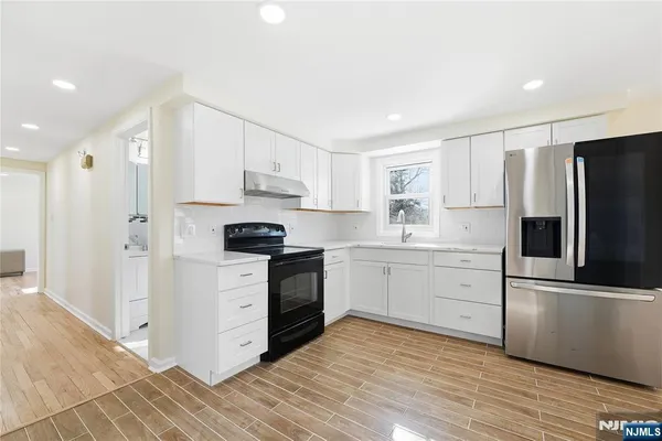 a kitchen with a refrigerator stove and white cabinets
