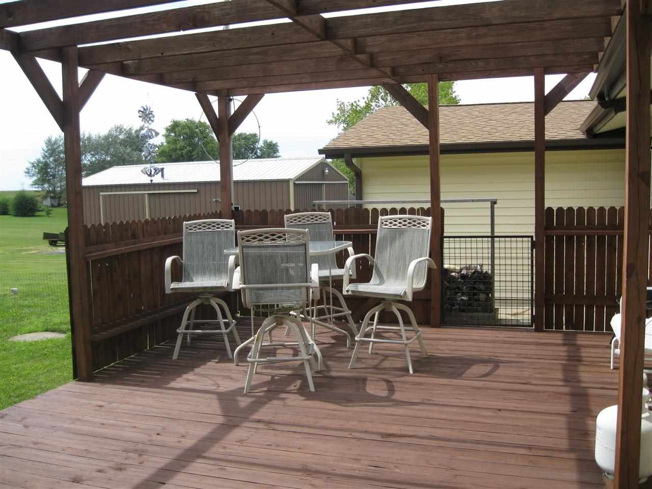 7114 Stephens Road Rockton, IL 61072 - Photo 15 of 20 a view of a patio with table and chairs under an umbrella with wooden floor