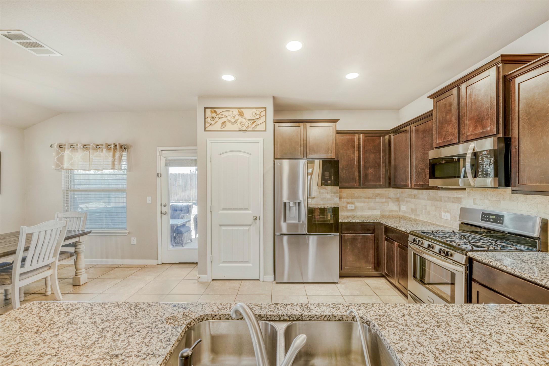 952 Palo Duro Loop Round Rock, TX 78664 - Photo 19 of 37 a kitchen with stainless steel appliances granite countertop a stove top oven a sink and a refrigerator