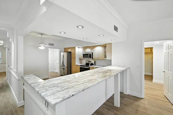 a bathroom with a granite countertop sink and a wooden floor