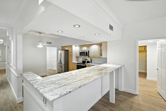 a bathroom with a granite countertop sink and a wooden floor