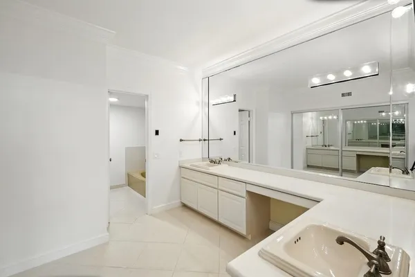 a large bathroom with a double vanity sink a mirror and a bathtub
