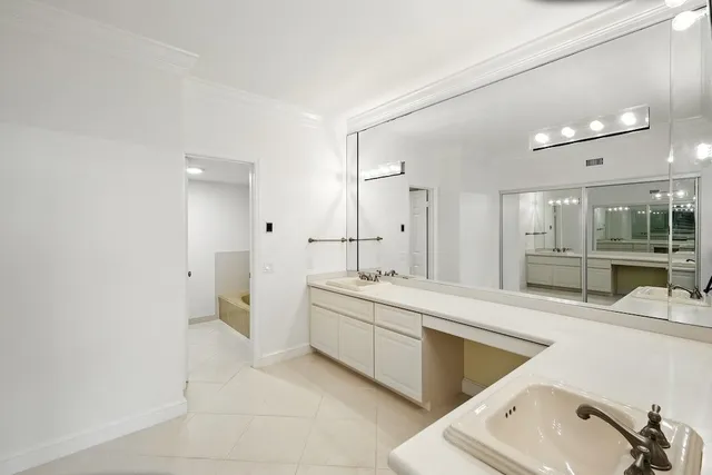 a large bathroom with a double vanity sink a mirror and a bathtub