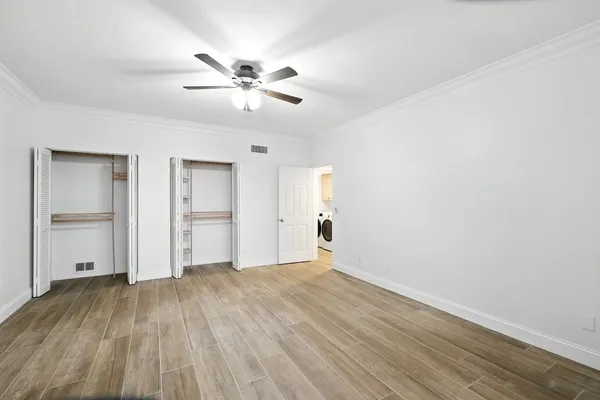 a view of an empty room with wooden floor