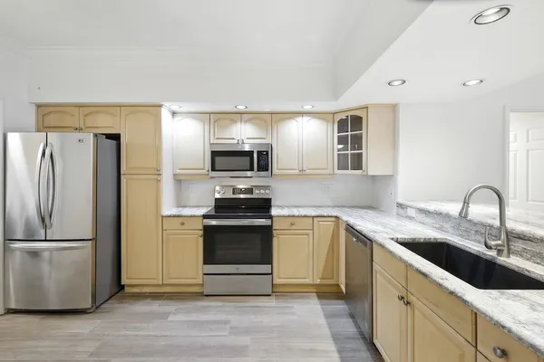 a kitchen with stainless steel appliances granite countertop a refrigerator sink and stove