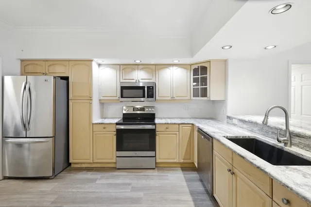 a kitchen with stainless steel appliances granite countertop a refrigerator sink and stove