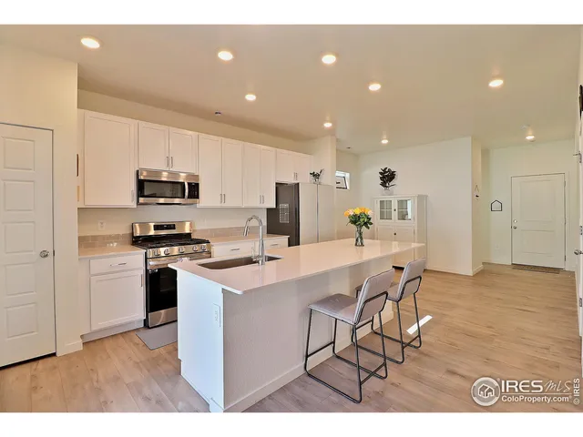 a kitchen with kitchen island white cabinets and stainless steel appliances