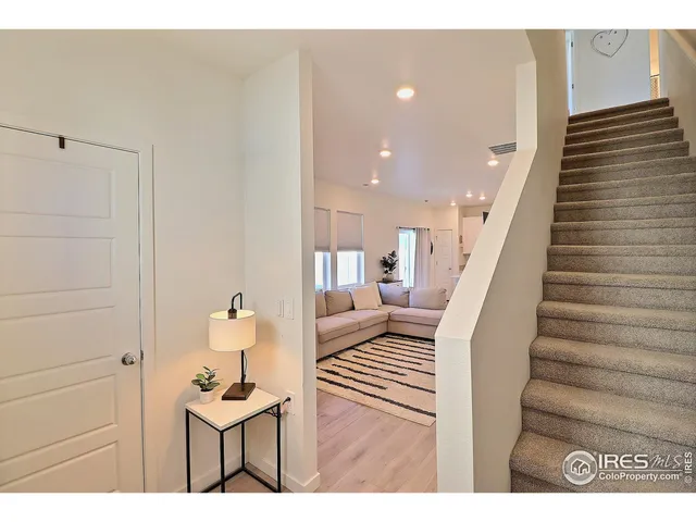 a view of a living room filled with furniture and stairs