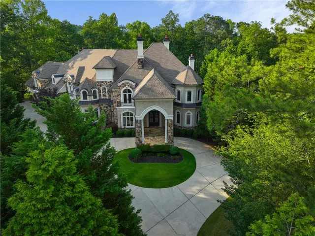 a aerial view of a house with a yard and large trees
