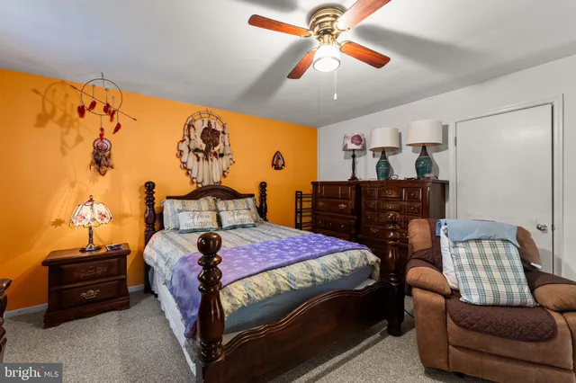 a bedroom with a bed a dresser and a chandelier