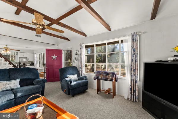 a living room with furniture a flat screen tv and a chandelier