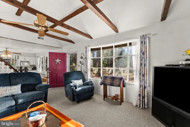 a living room with furniture a flat screen tv and a chandelier