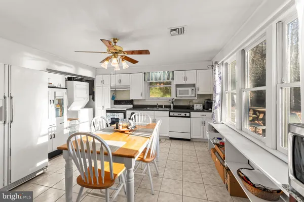 a kitchen with a table chairs microwave and cabinets