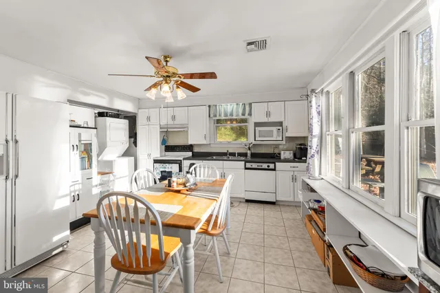 a kitchen with a table chairs microwave and cabinets