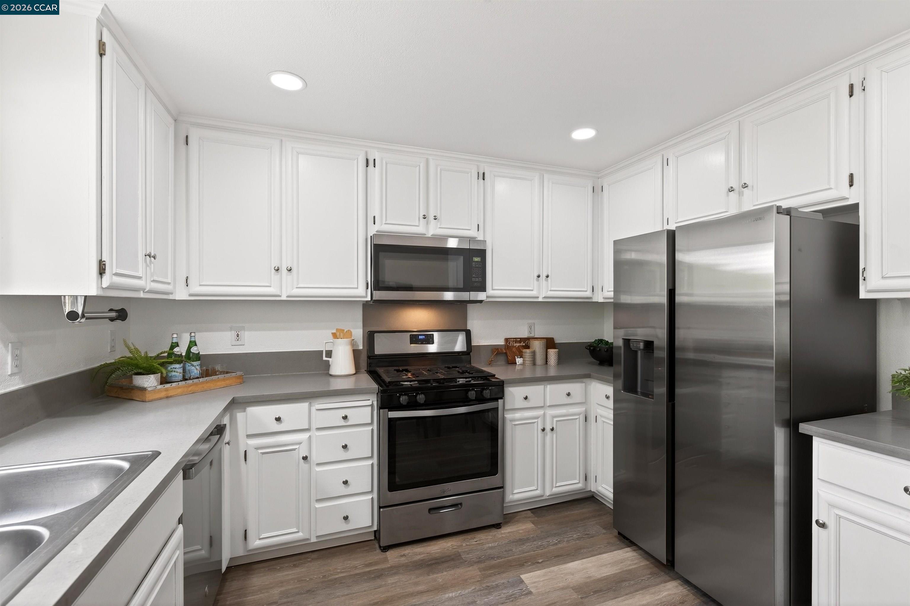 124 Coralflower Lane San Ramon, CA 94582 - Photo 10 of 47 a kitchen with white cabinets and stainless steel appliances