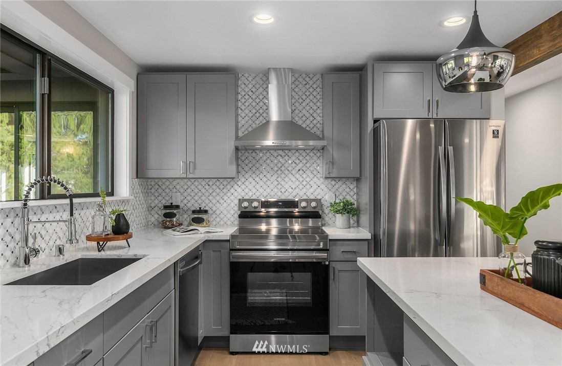 303 217th Place Southwest Bothell, WA 98021 - Photo 11 of 38 a kitchen with stainless steel appliances granite countertop a stove a refrigerator and a sink