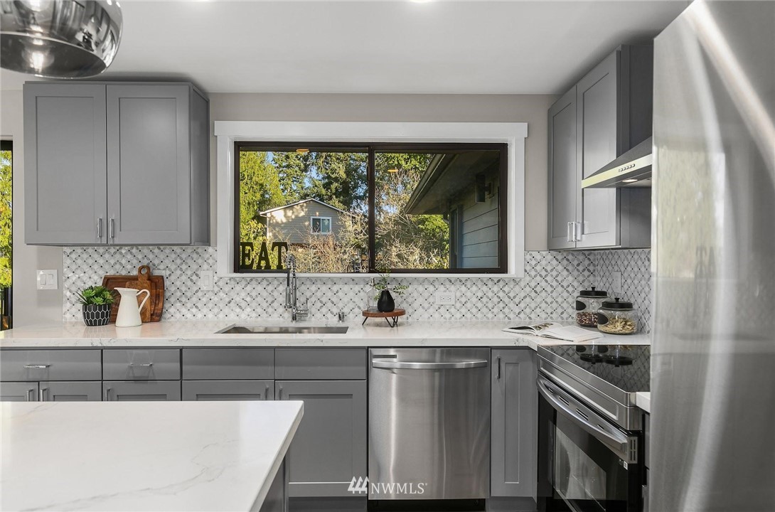 303 217th Place Southwest Bothell, WA 98021 - Photo 12 of 38 a kitchen with a sink stove and cabinets