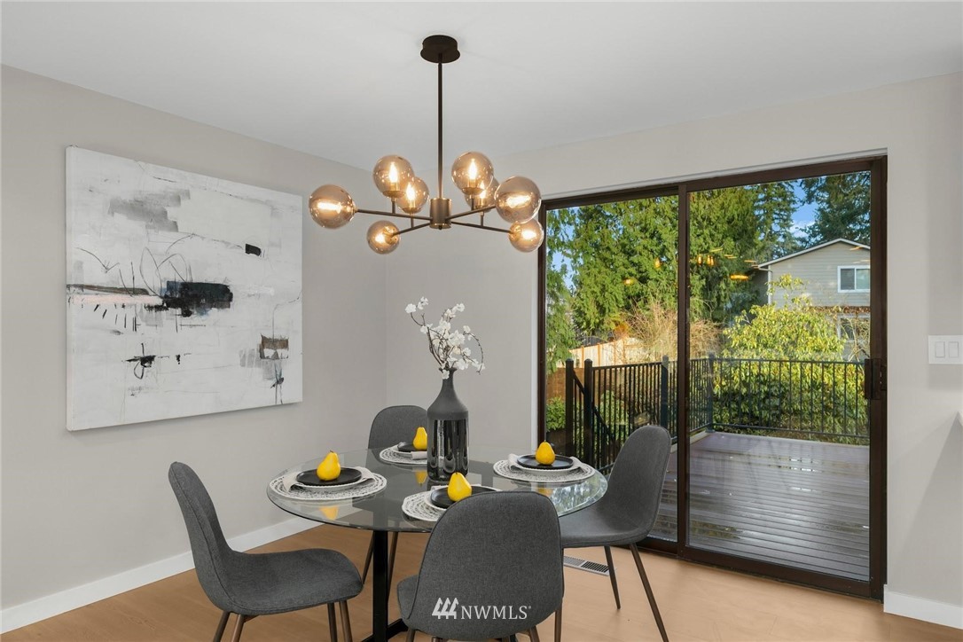 303 217th Place Southwest Bothell, WA 98021 - Photo 13 of 38 a dining room with furniture a chandelier and wooden floor