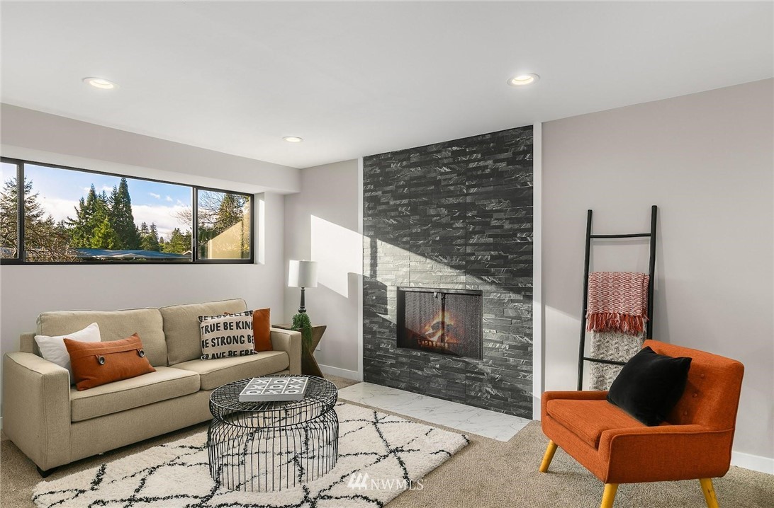 303 217th Place Southwest Bothell, WA 98021 - Photo 24 of 38 a living room with furniture a flat screen tv and a fireplace
