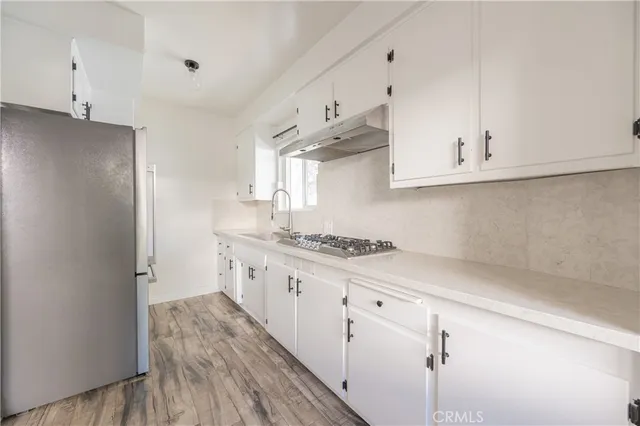 a kitchen with granite countertop a sink cabinets stainless steel appliances and a counter space
