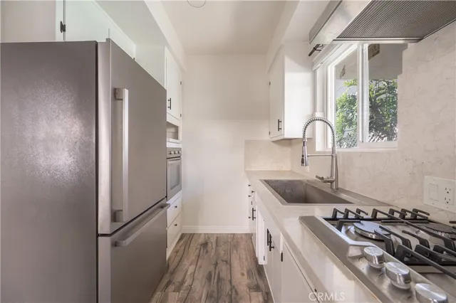 a kitchen with sink a refrigerator and a stove