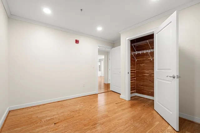 an empty room with wooden floor and closet