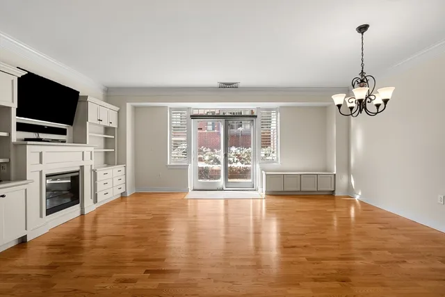 a view of a livingroom with a flat screen tv wooden floor and a fireplace