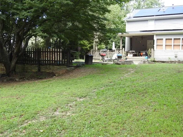 a view of an house with backyard and deck