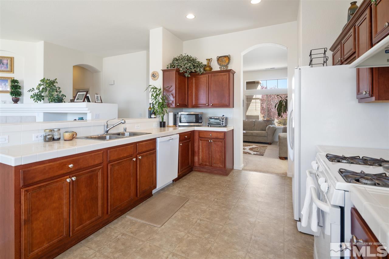 1448 Orca Way Reno, NV 89506 - Photo 9 of 9 a kitchen with stainless steel appliances a sink stove and cabinets