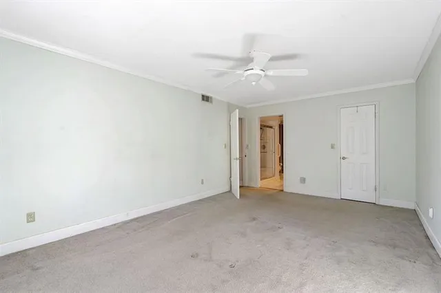 an empty room with an entryway and fan