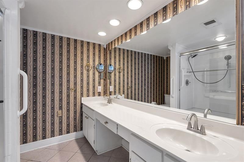 6851 Roswell Road, Unit D14 Atlanta, GA 30328 - Photo 18 of 30 a bathroom with a double vanity sink and mirror
