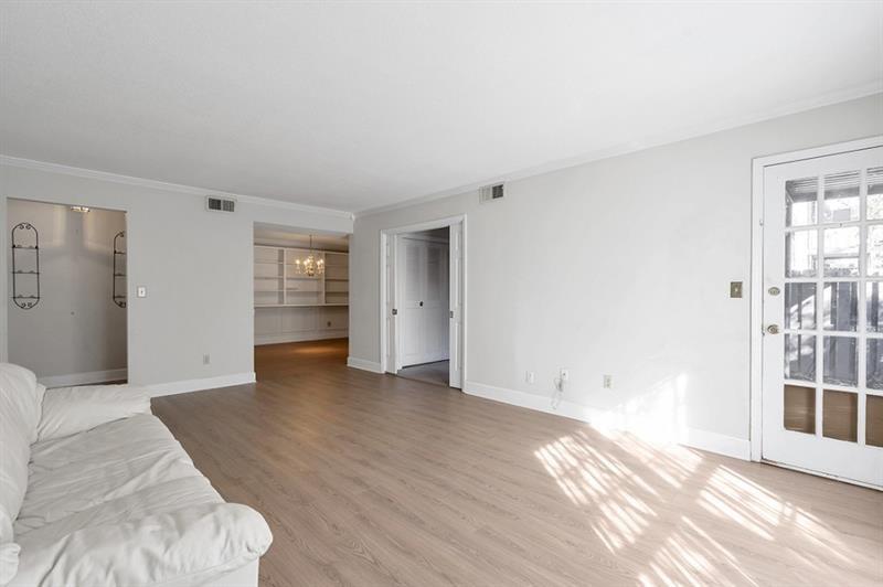 6851 Roswell Road, Unit D14 Atlanta, GA 30328 - Photo 7 of 30 a view of an empty room with wooden floor and a window