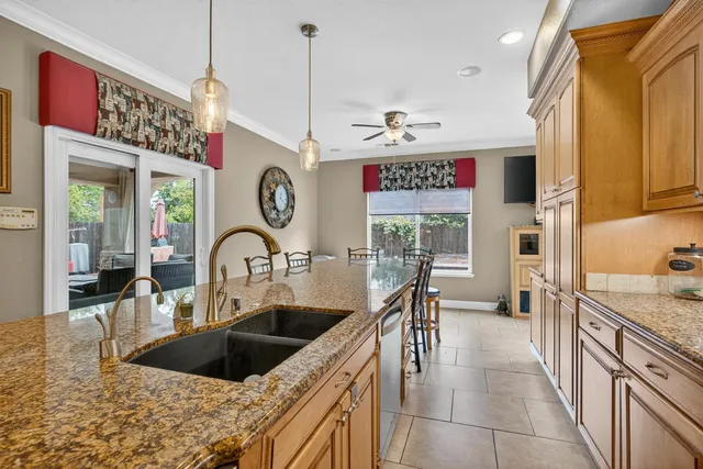 a kitchen with stainless steel appliances granite countertop a sink and a refrigerator