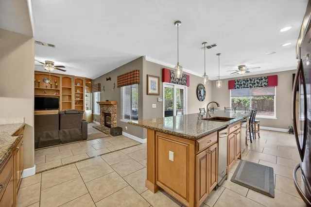 a kitchen with stainless steel appliances granite countertop a stove a sink and a refrigerator