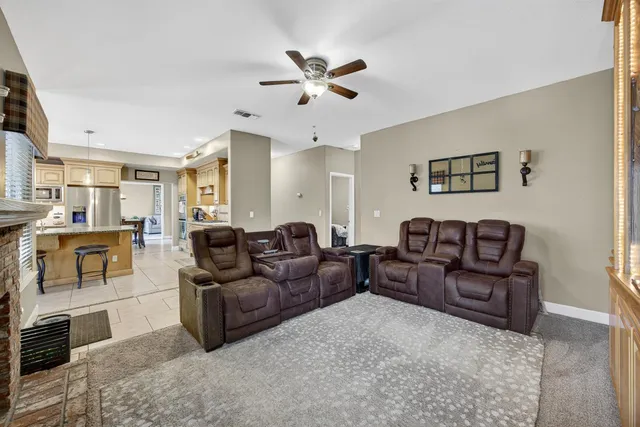 a living room with furniture and a ceiling fan
