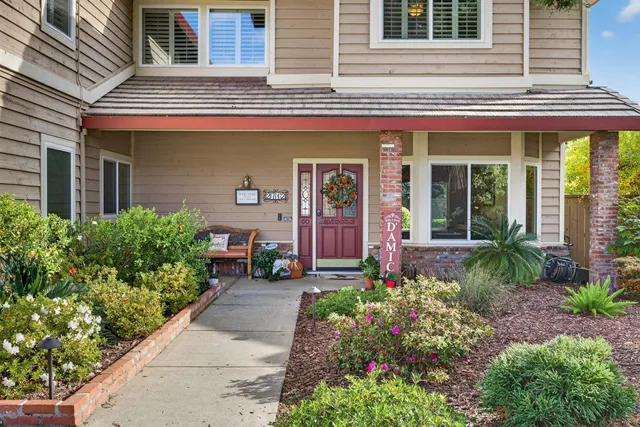 front view of a brick house with potted plants