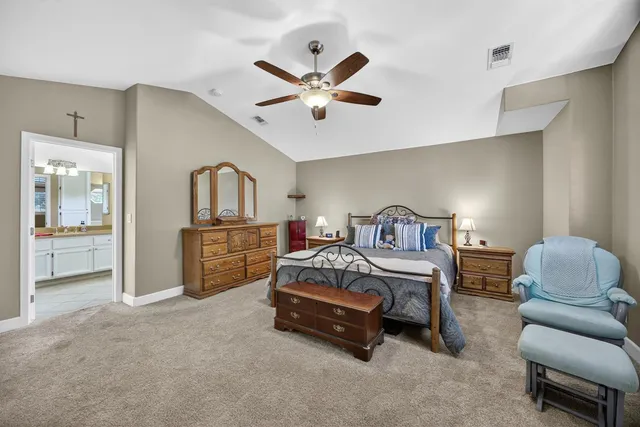 a spacious bedroom with a bed furniture and a large window