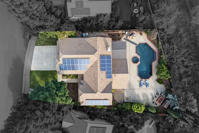 an aerial view of residential houses with outdoor space and lake view