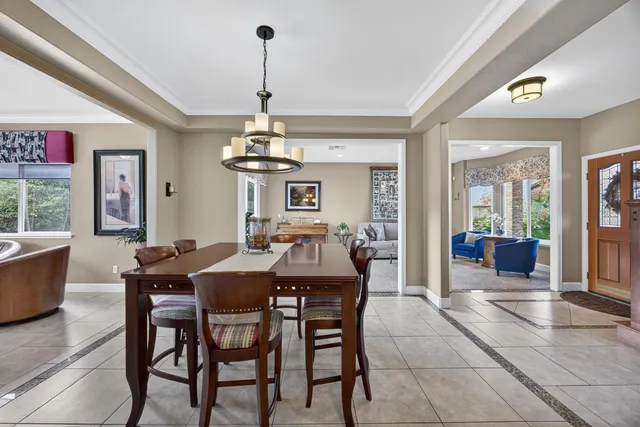 a dining room with furniture a chandelier and window