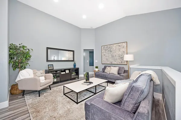 a spacious bedroom with a bed a dresser and wooden floor