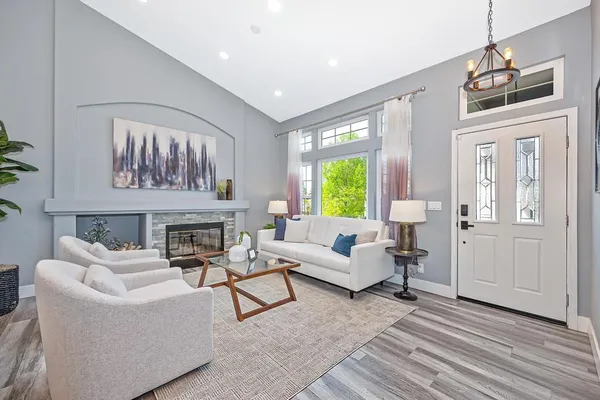 a dining room with wooden floor a chandelier a wooden table and chairs