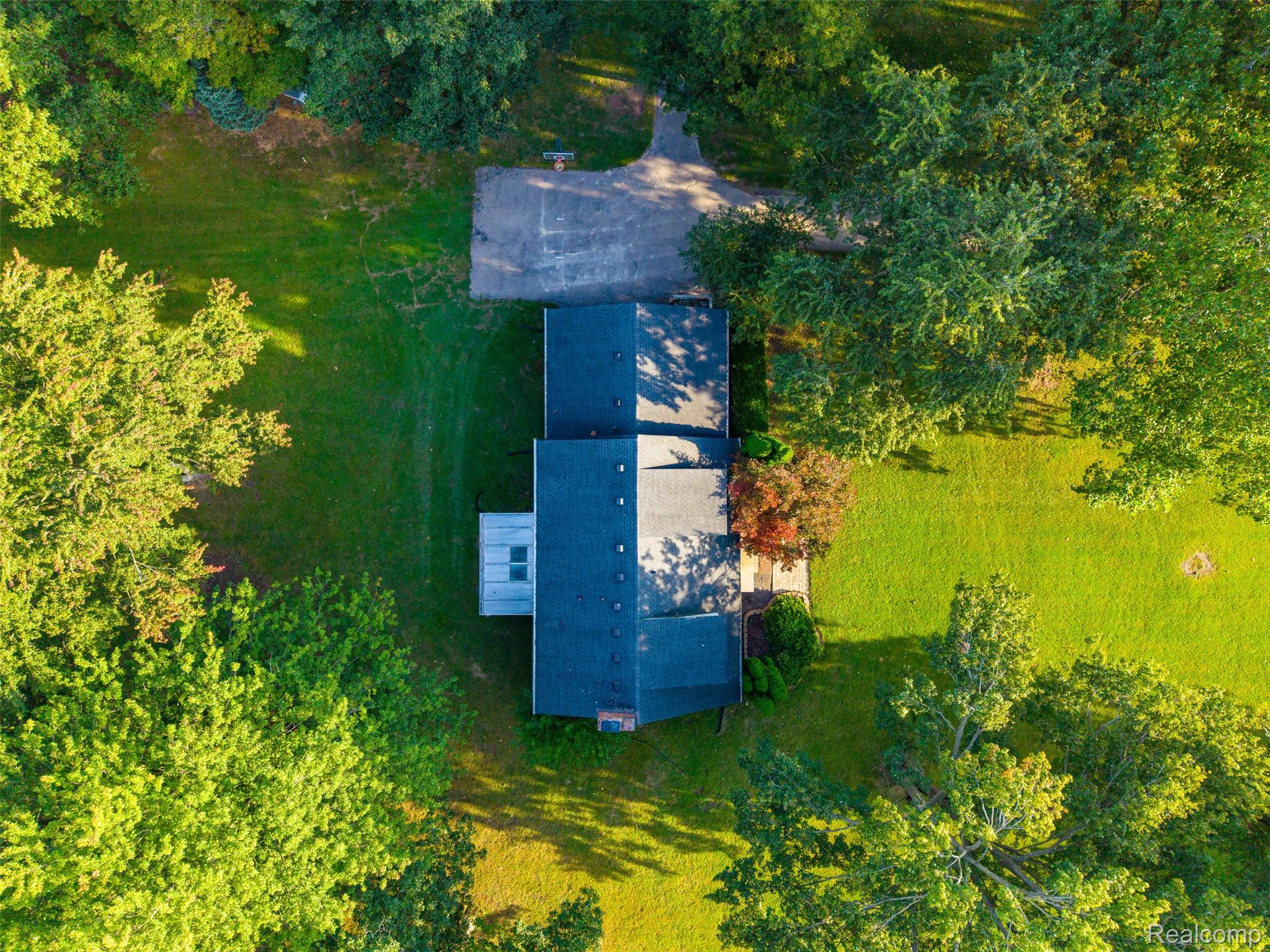 26516 Romine Road New Boston, MI 48164 - Photo 51 of 62 Expansive grounds featuring a large paved court, mature trees, and a substantial lawn area